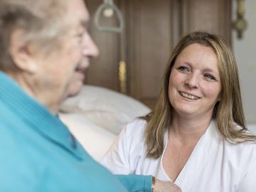 A nurse talking to an eldery woman in her room